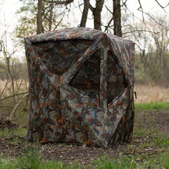 Portable hunting blind in woodland environment
