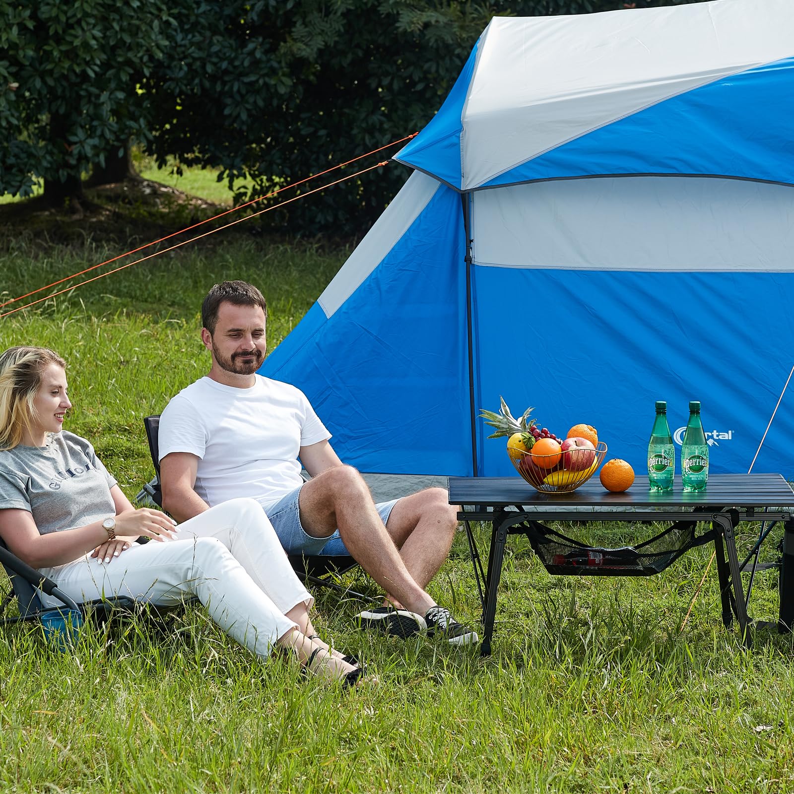 Portal camping table adjustable legs extended for stable use on uneven ground.
