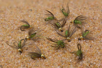 Region Fishing trout beadhead caddis pupa flies assortment on the riverbank
