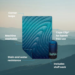 Rumpl Original Puffy Blanket Ocean Fade on campsite for warmth