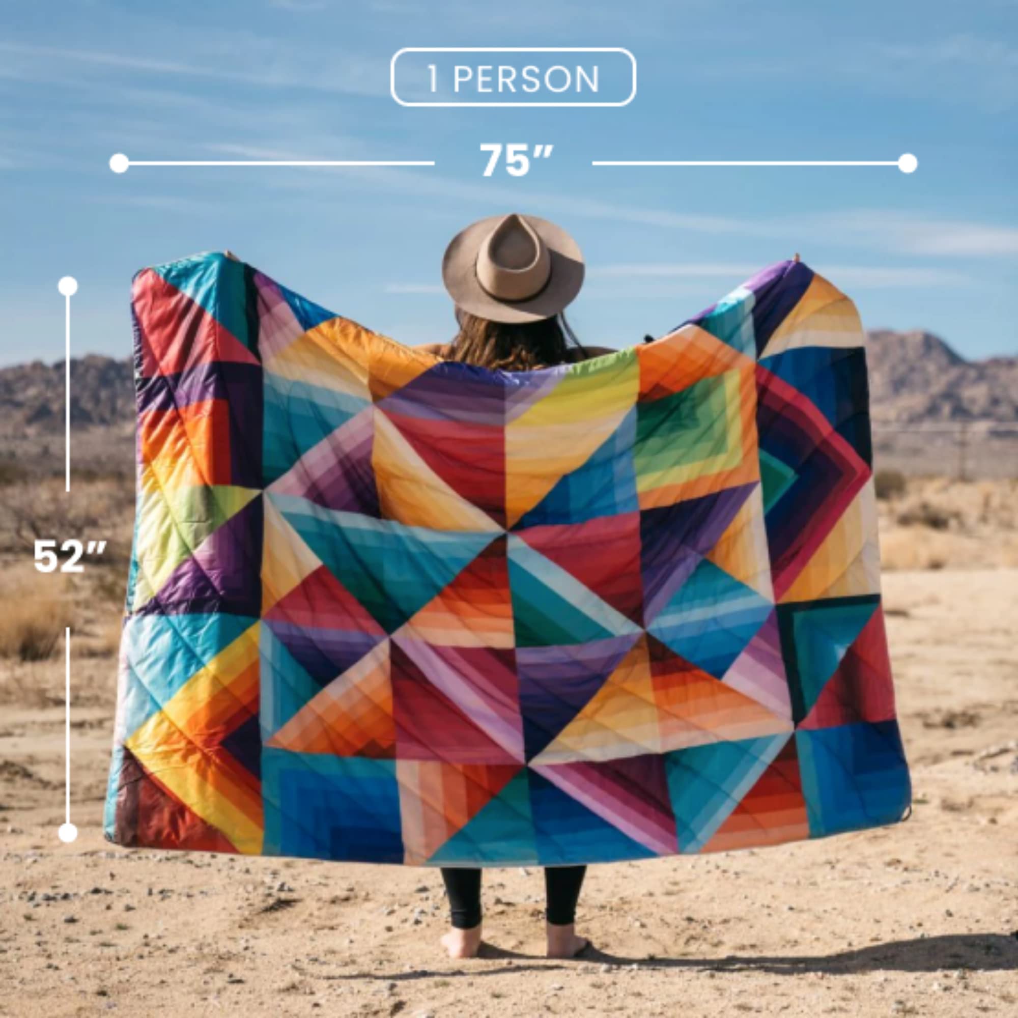 Rumpl Original Puffy Blanket Ocean Fade spread across a picnic table