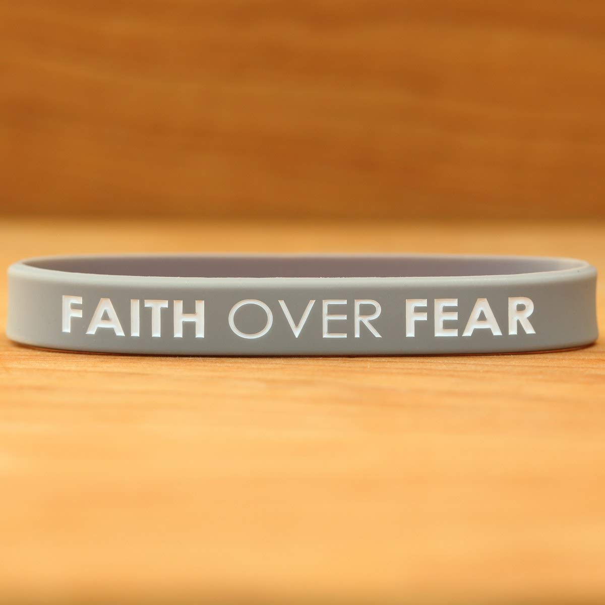 Close up of SayitBands Faith Over Fear with color filled debossed lettering