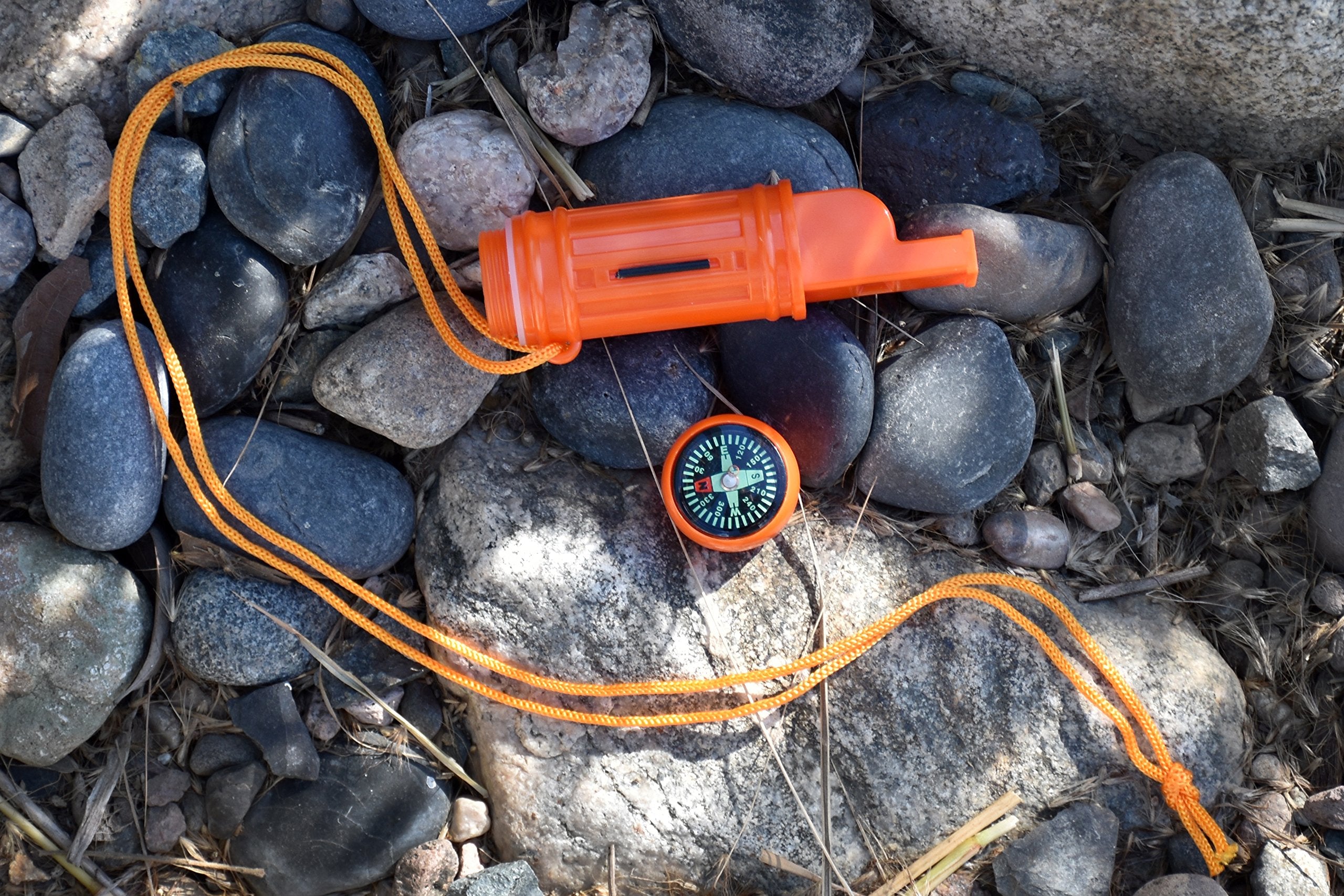 SE orange survival whistle features a waterproof compartment for small items.