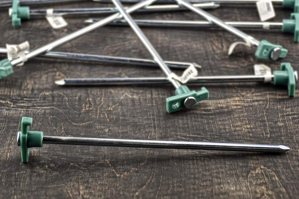 SE heavy-duty tent pegs anchored in dirt and grass for stability.