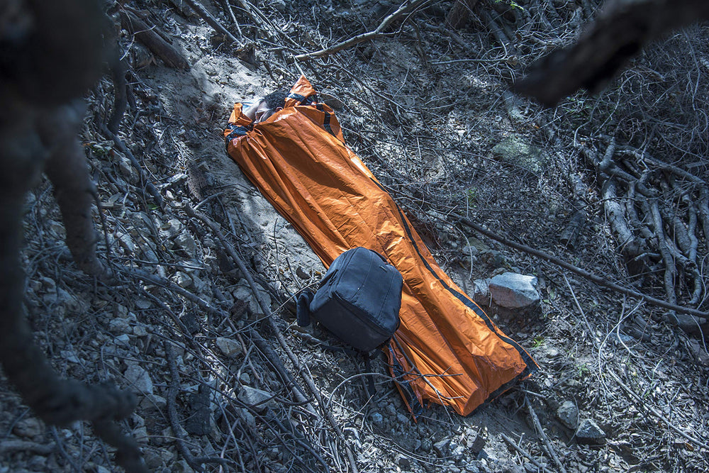 SE Survivor orange sleeping bag open showing compact, lightweight warmth-ready design
