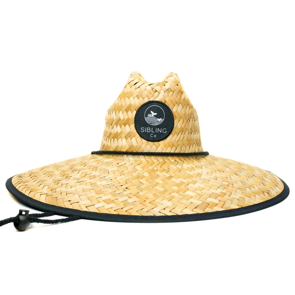 Sibling Co lifeguard-style straw hat providing broad shade at the beach