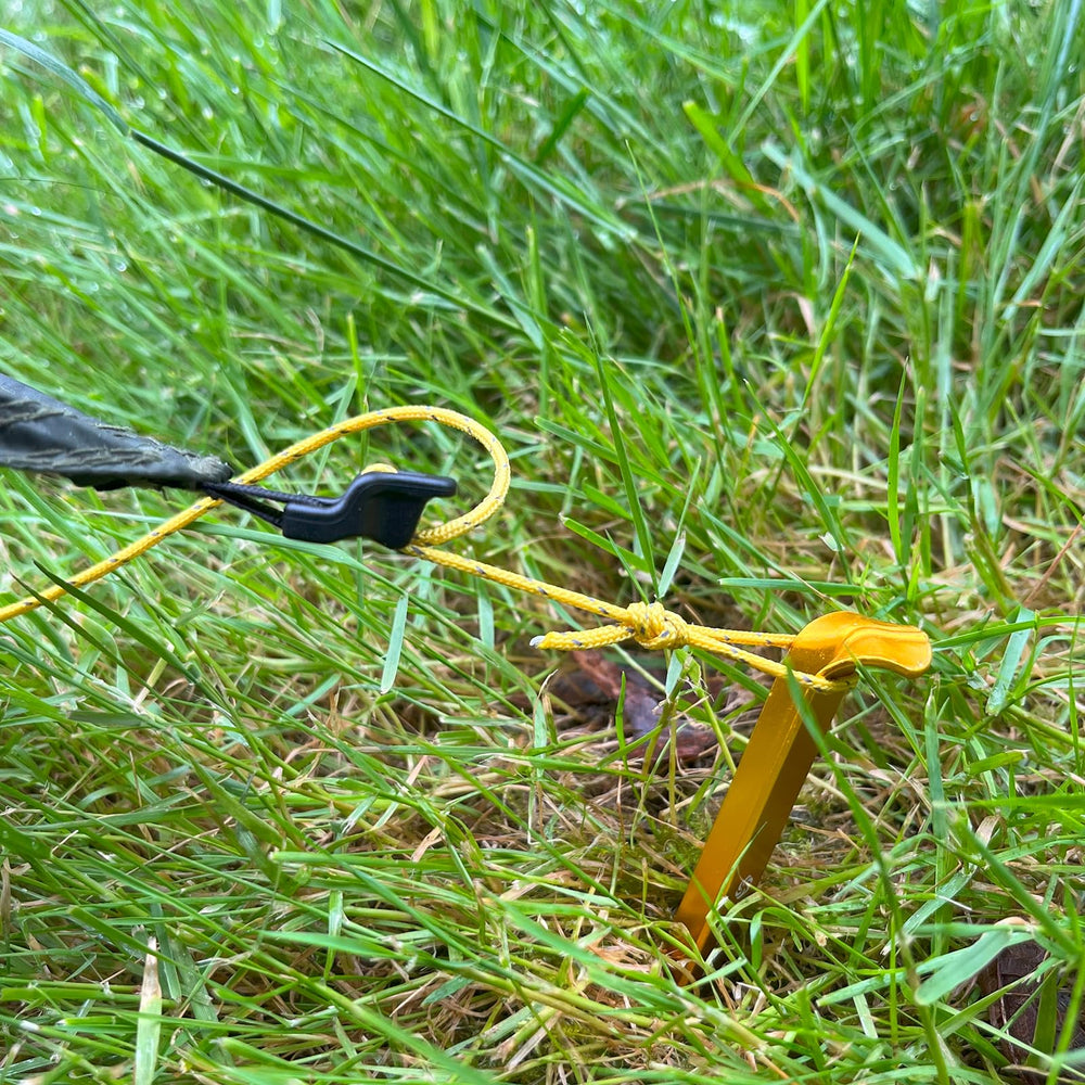 Six Moon Designs stake set driven into ground securing a tent on uneven terrain