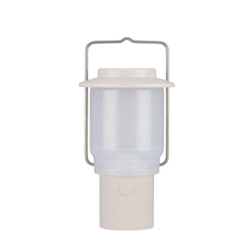 Snow Peak Mini Hozuki battery-powered lantern emitting warm ambient light at a campsite