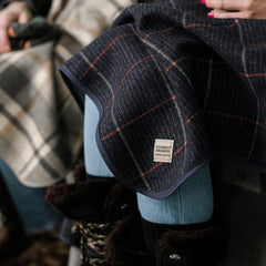 Stormy Kromer plaid wool blanket draped over sofa for cozy lounging