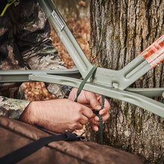 Backpack straps attached to treestand in use