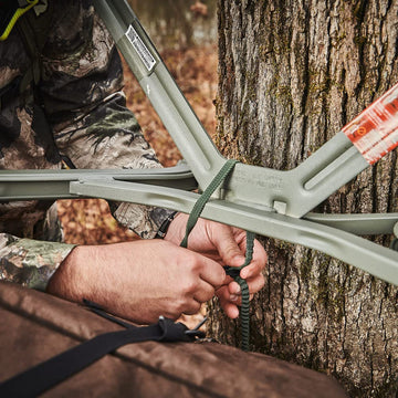Summit Treestands shoulder straps attached to a tree stand for comfortable climbing.