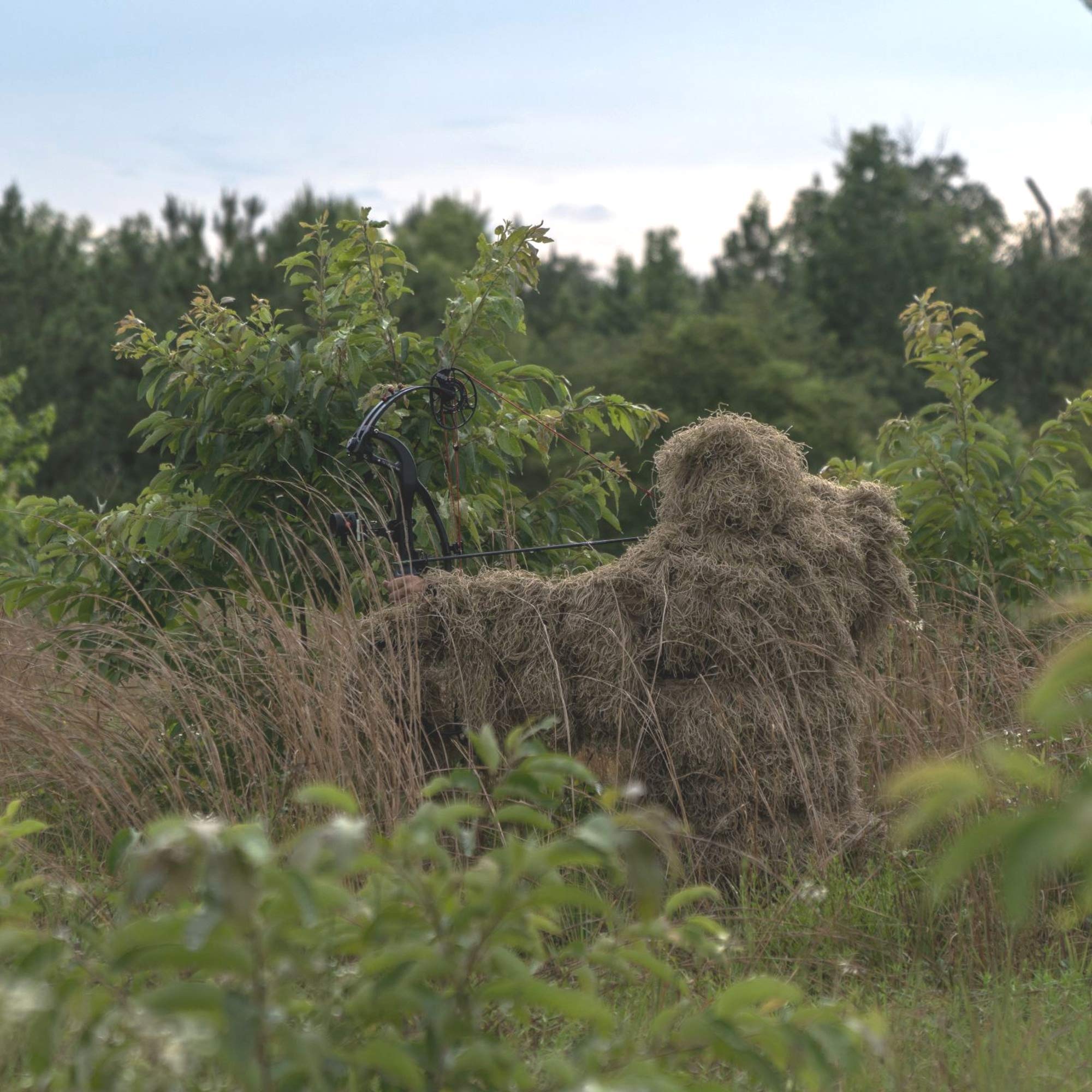 Tencen ghillie suit in forest environment demonstrates natural camouflage.