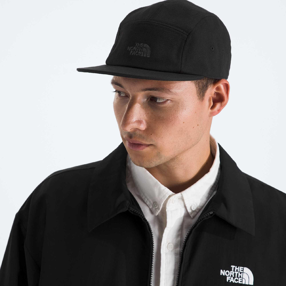 The North Face Norm Camp Hat flat brim shading eyes on sunny trails.