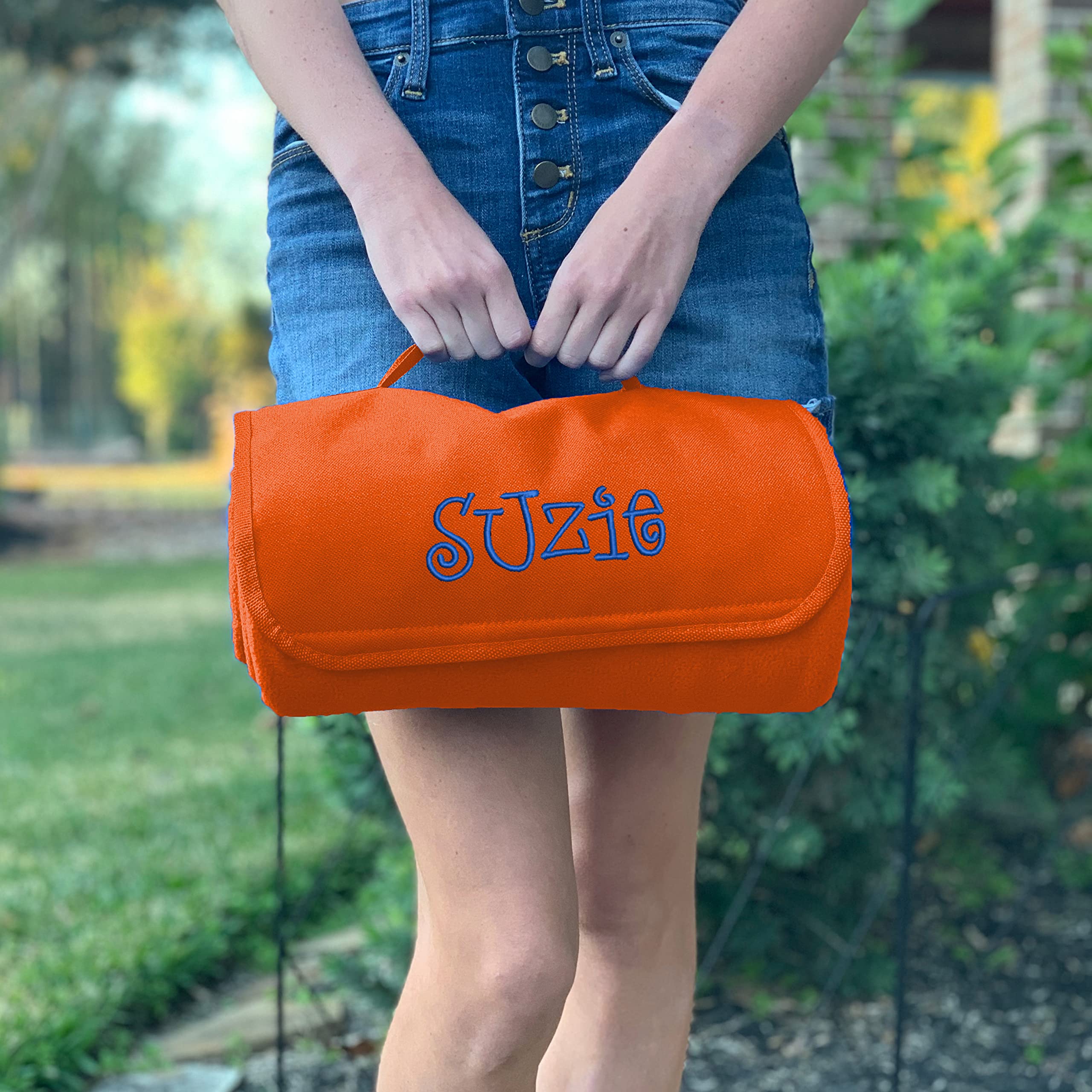 Threadart soft fleece blanket in orange folds compactly with Velcro closure.
