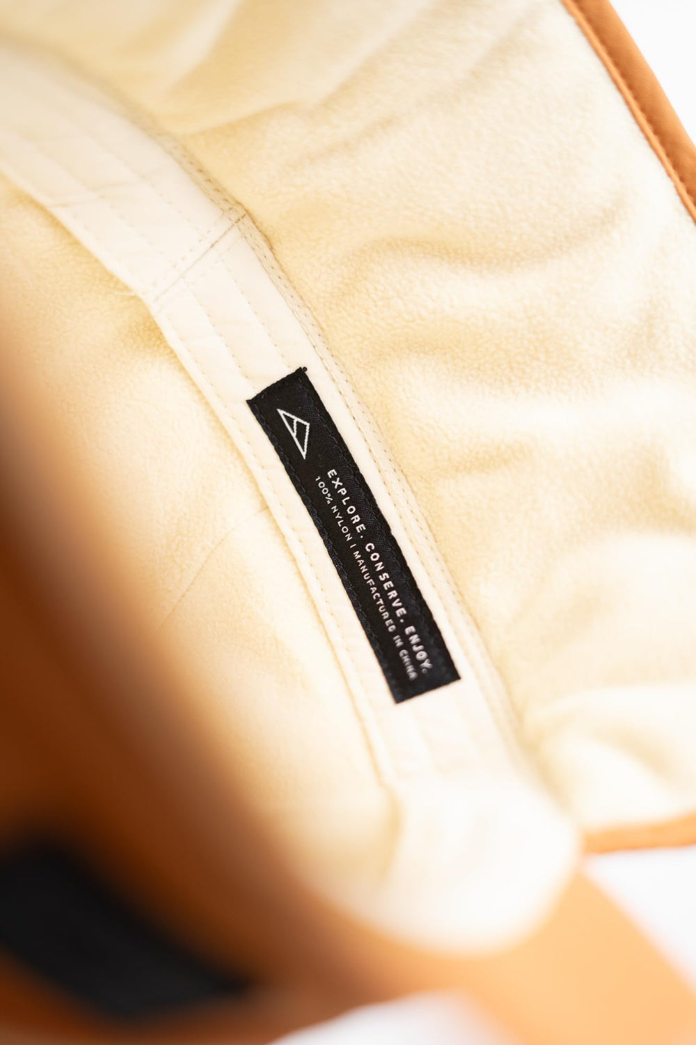 Tillak Tahoma Hat light brown color pairs with winter gear.