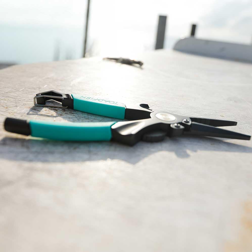 Toadfish 8in Inshore Pliers quick-release carabiner for easy attachment.