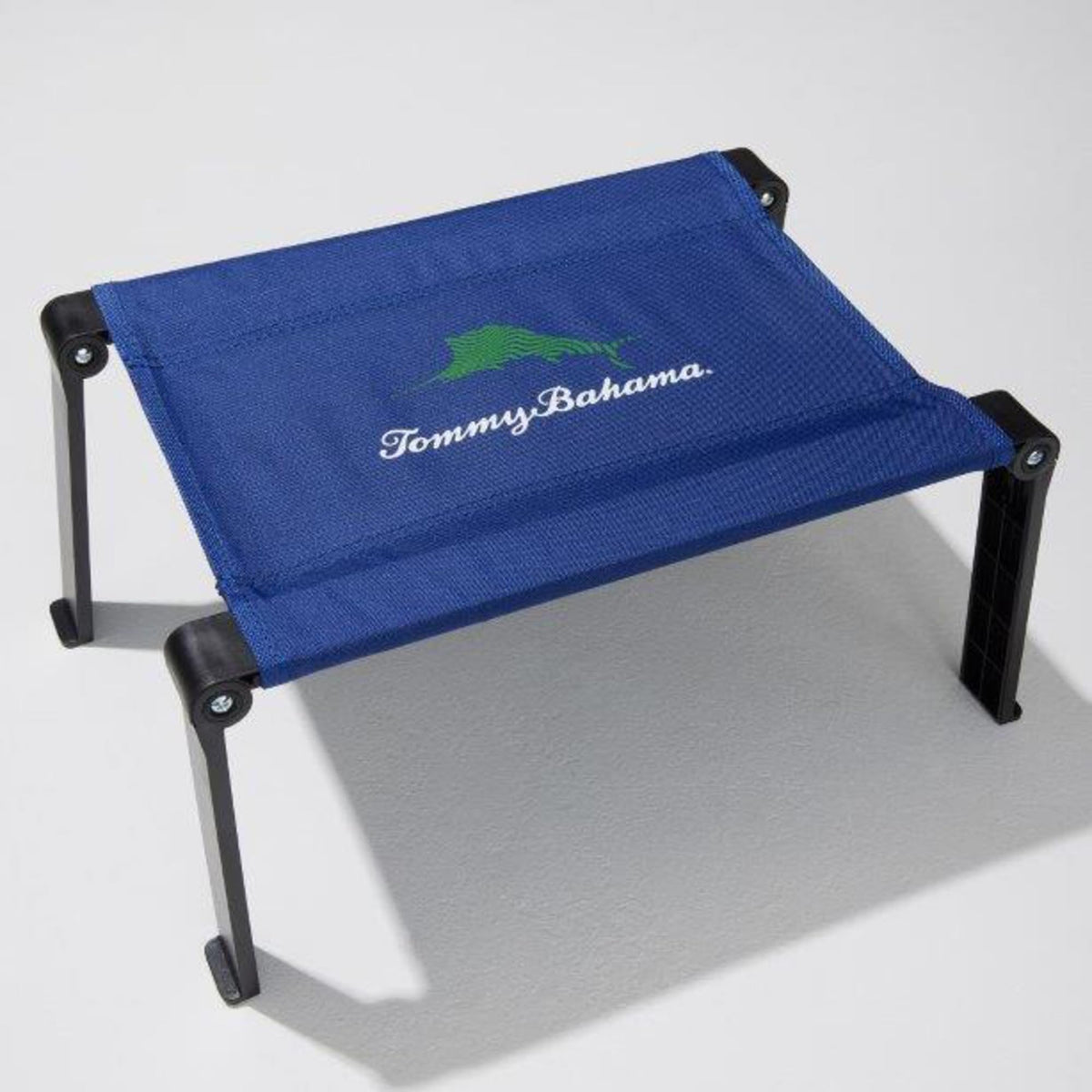 Tommy Bahama Ultra Compact Fabric Beach Folding Table on sand offers a stable snack surface.