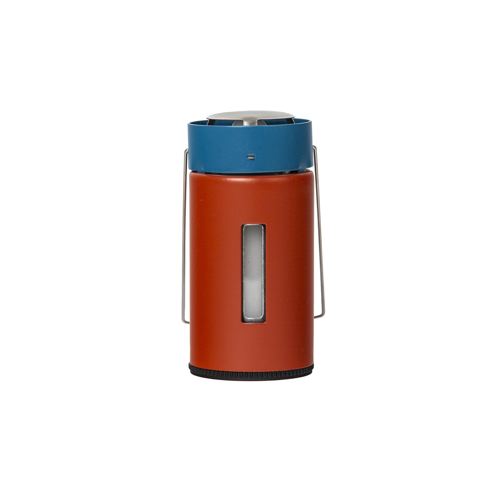 UCO Original Candle Lantern glows softly in a backyard or campsite setting.