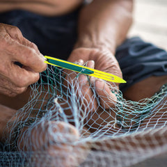 Close-up of uxcell yellow netting needle shuttle for precise threading.