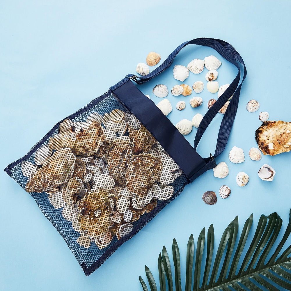 Seashells and beach treasures organized in clam bags on sand