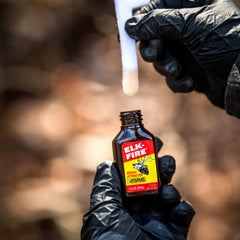 Amber glass Elk Fire bottle with cap visible, showcasing durable field storage.