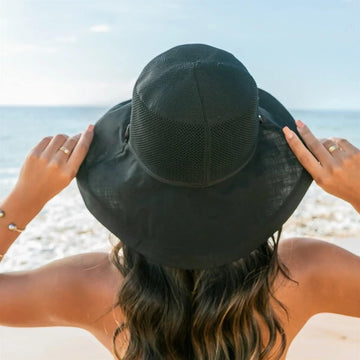 Model wearing sun hat at beach