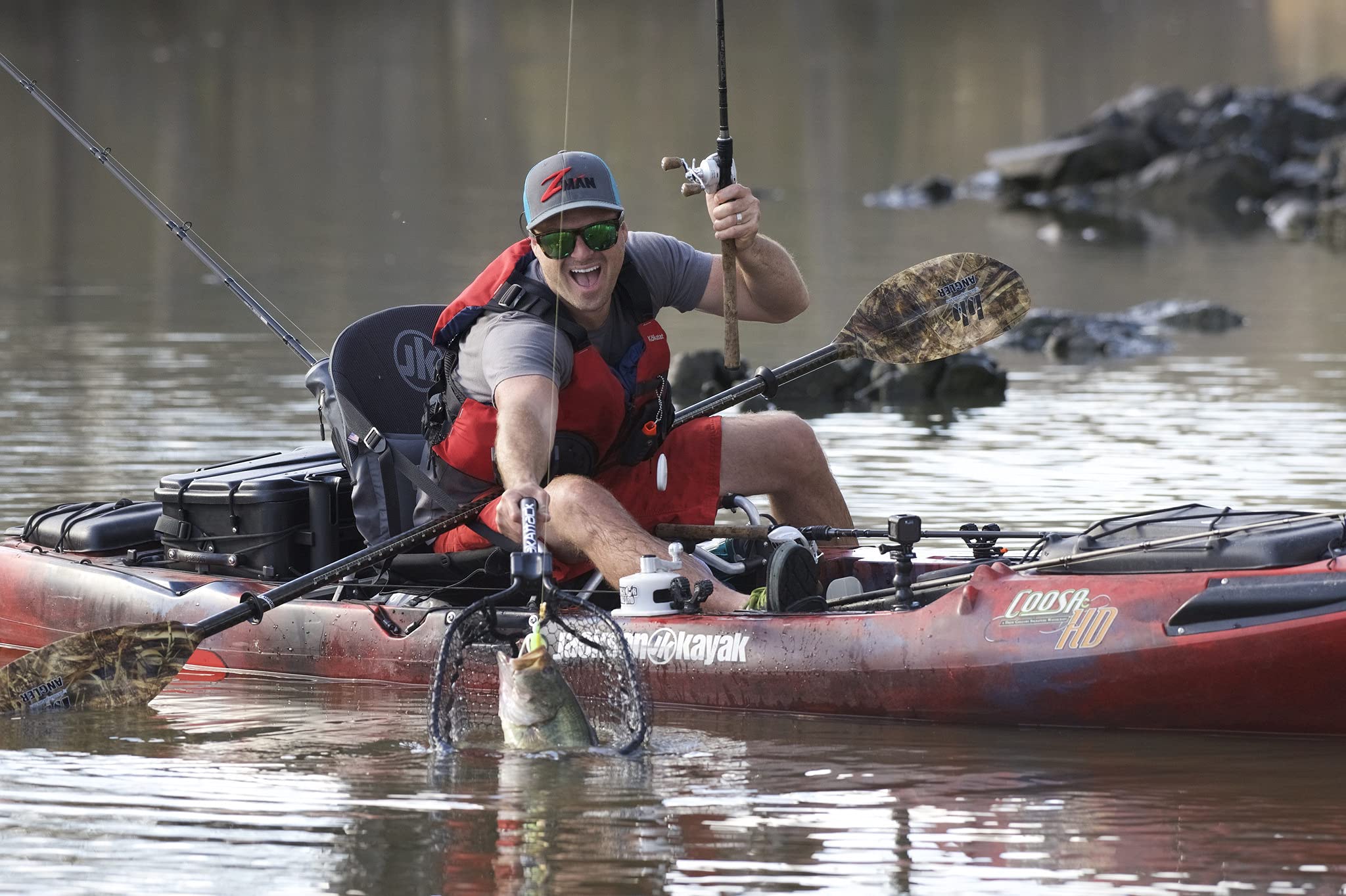 Angler using the net from a kayak