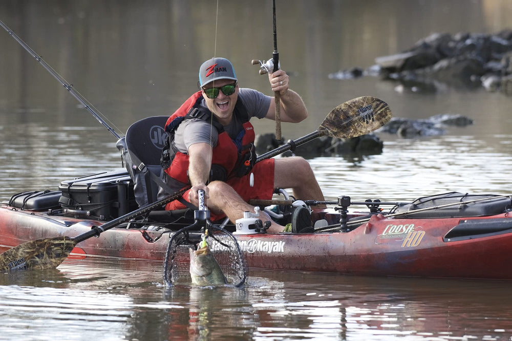 Angler using the net from a kayak