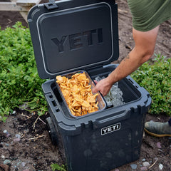 Roadie wheeled cooler holding two dry baskets for organized storage.